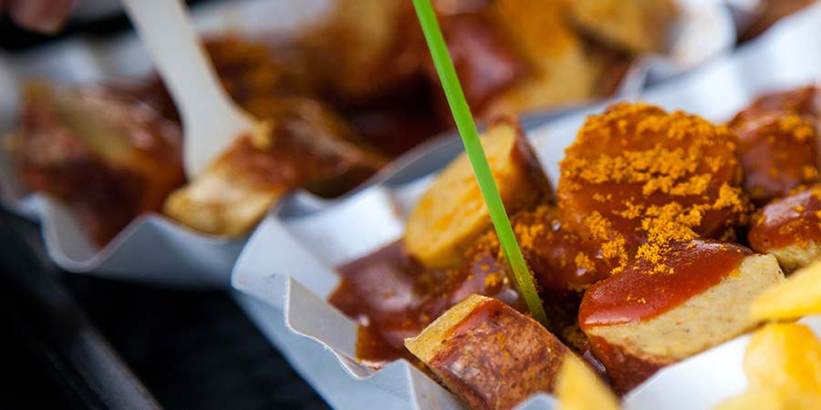 Portions of Currywurst in paper food containers.