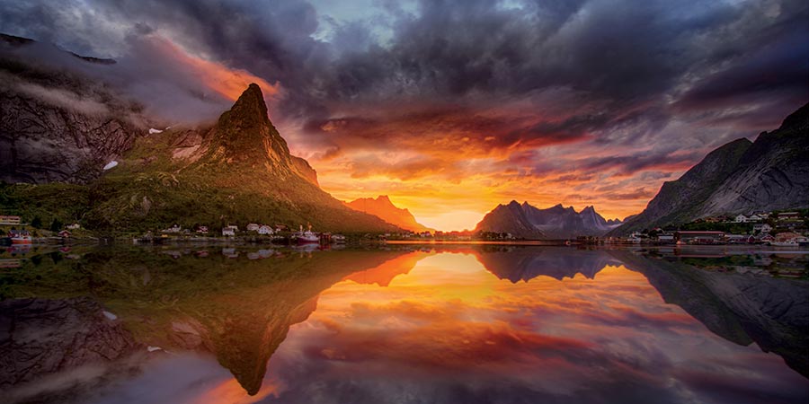 The dramatic Midnight Sun of Lofoten turns the dark sky a vibrant orange.